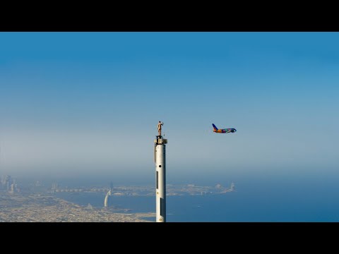 Emirates Airline Got That Woman To Stand On The Burj Khalifa Again, This Time With A Plane Flying Directly Behind Her